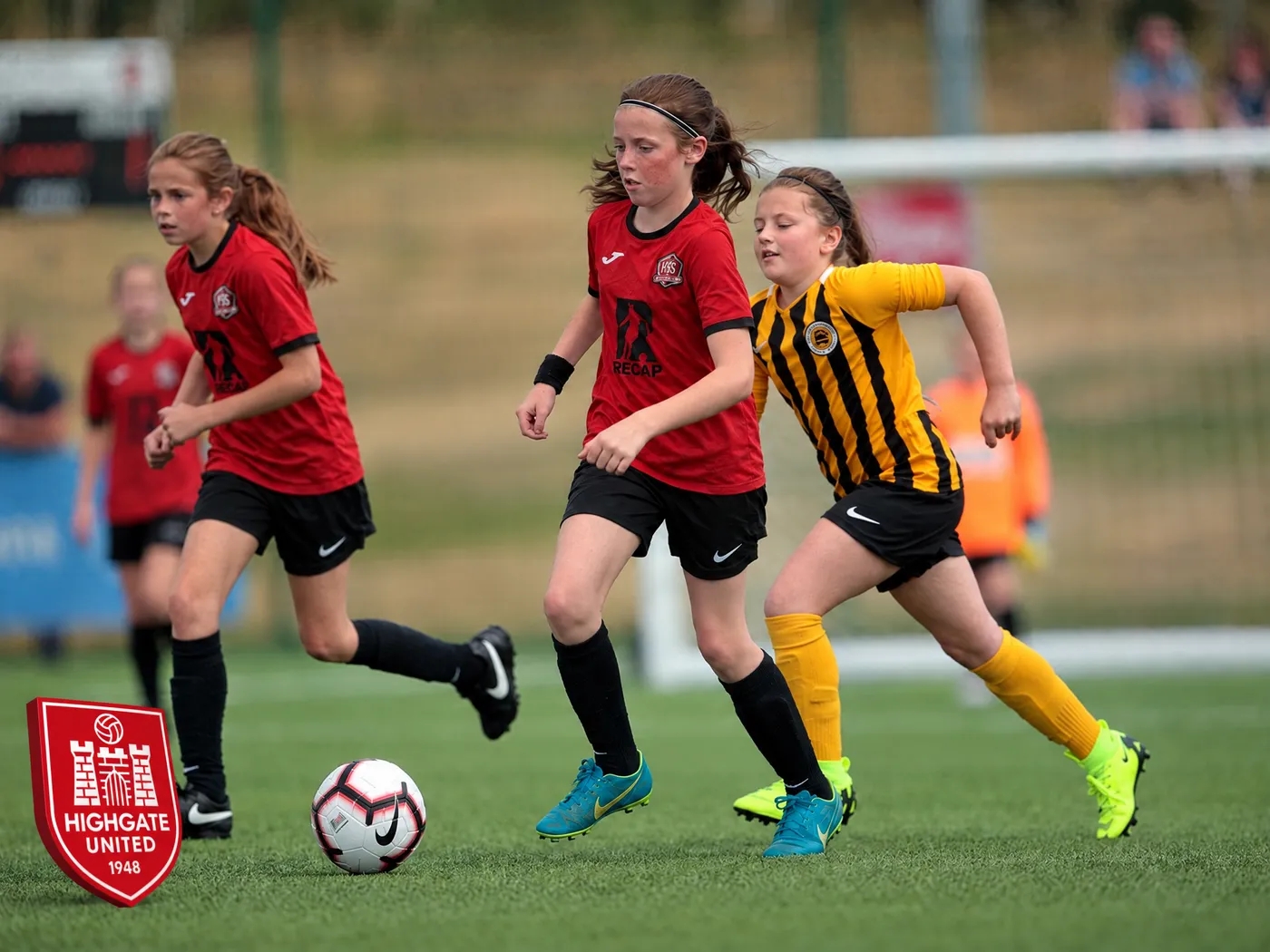 Highgate United players running with the ball in Recap-sponsored shirts